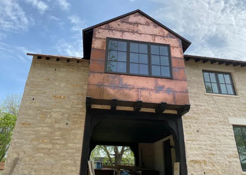 Copper metal panel facade on a stone building for Roof Repair in Perry